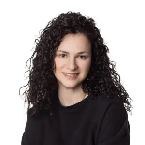 Woman with curly hair smiling at camera.