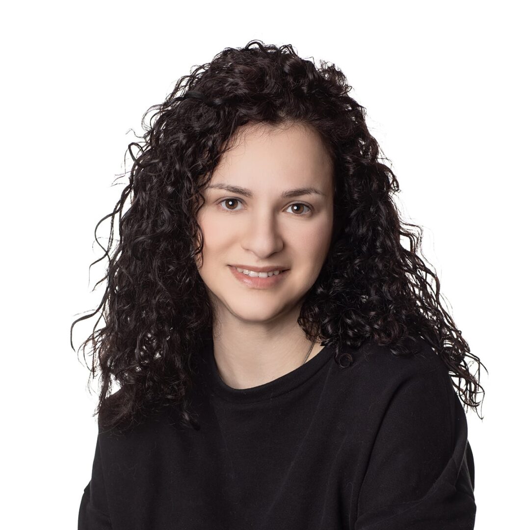 Woman with curly hair smiling at camera.