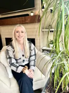 Woman in plaid sweater sits in a chair.