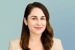 Woman smiling in a beige jacket.