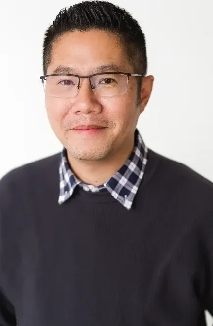 Man wearing glasses and black sweater.