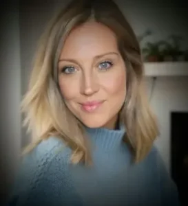 Woman with blonde hair wearing a blue sweater.