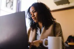 Woman working on laptop in cafe.