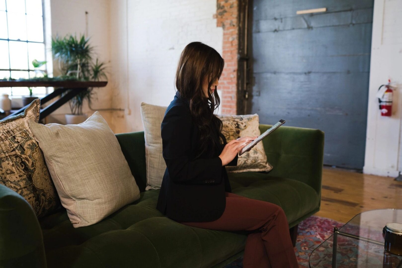 Woman in a blazer working on a tablet.