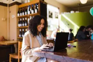 Woman working on laptop in cafe.