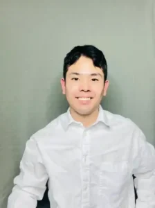 Man in white shirt smiling at camera.