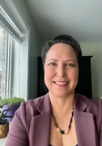 Smiling woman in a purple blazer.