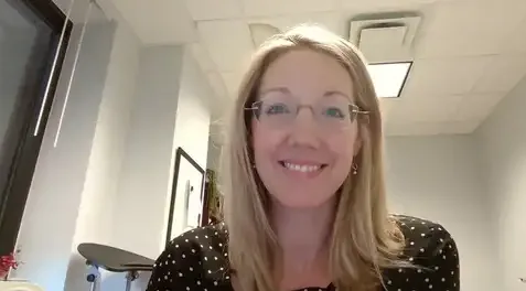 Woman with glasses smiling in office