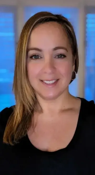 Woman smiling, long brown hair, black shirt.