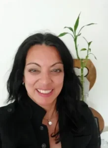 Woman with black hair smiling at camera.