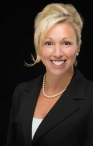 Smiling woman in a black blazer.