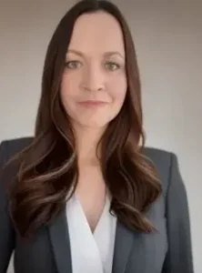 Woman with long brown hair in a suit.