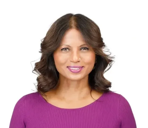 Smiling woman with brown hair and a purple shirt.