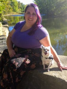 Woman with purple hair and a white dog.