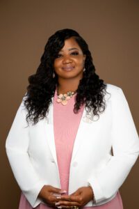 Smiling woman in white blazer, pink blouse