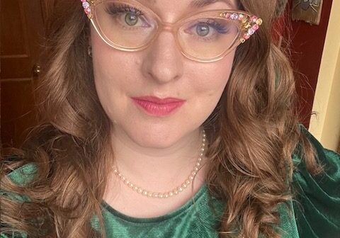 amoreena 2024 Woman with long brown hair wearing cat-eye glasses.