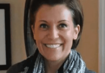 A woman with short hair wearing a scarf.