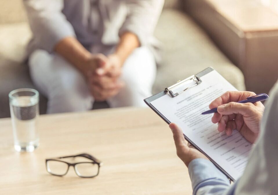 Person filling out a form during therapy.