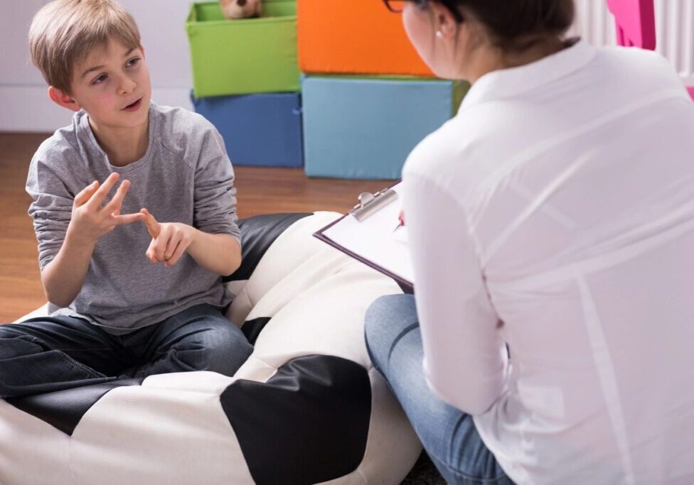 Boy talking to therapist in office.