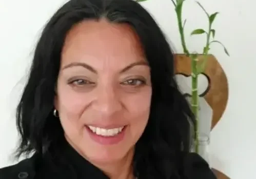 Woman with black hair smiling at camera.