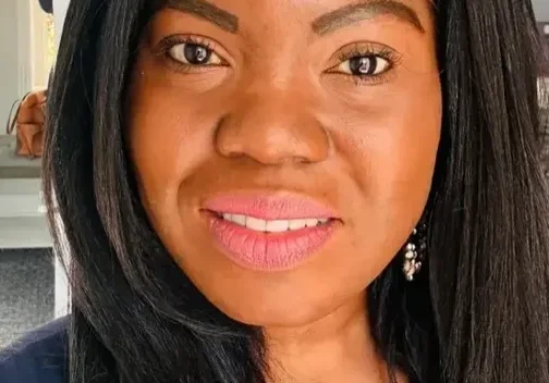 Woman with long black hair smiling.